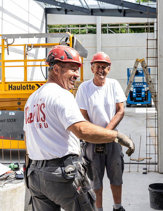Zwei Mitarbeiter von Mathis Bau stehen auf einer Baustelle